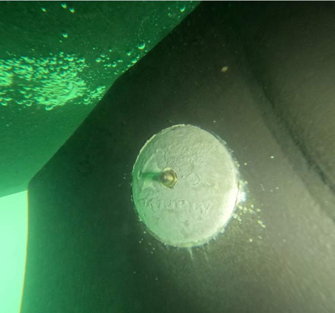 Professional underwater repair showing a newly replaced round hull zinc anode securely fastened to a boat bottom to provide continuous protection against marine metal corrosion.